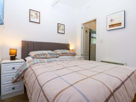 A bedroom with a bed and bedside table at River's Nook in Llangynog