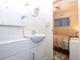 A bathroom with a sink and mirror at River's Nook in Llangynog