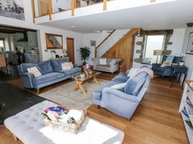 A living room with sofas and a table at Crane Field Laithe in Otterburn, North Yorkshire