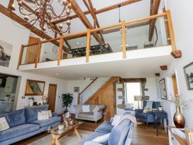 A living room with furniture and stairs at Crane Field Laithe in Otterburn, North Yorkshire