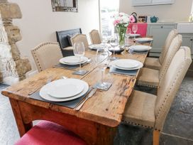 A dining area with a wooden table and chairs at Crane Field Laithe in Otterburn, North Yorkshire