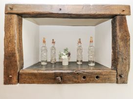 A decorative shelf with bottles and flowers at Crane Field Laithe Otterburn, North Yorkshire