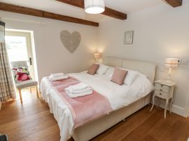 A bedroom with a bed, nightstand, and chair at Crane Field Laithe, Otterburn, North Yorkshire