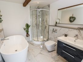 A bathroom with a bathtub and a shower at Crane Field Laithe Otterburn, North Yorkshire