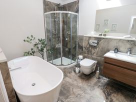 A bathroom with a bathtub, shower, sink, and toilet at Crane Field Laithe, Otterburn, North Yorkshire
