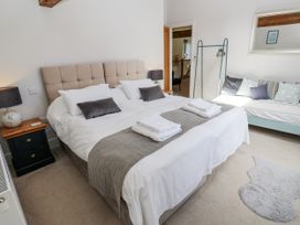 A bedroom with a large bed and a sofa at Crane Field Laithe in Otterburn, North Yorkshire