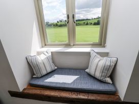 A window nook with cushions and a view at Crane Field Laithe in Otterburn, North Yorkshire