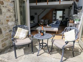 An outdoor patio with two chairs and a table holding champagne at Crane Field Laithe, Otterburn, North Yorkshire