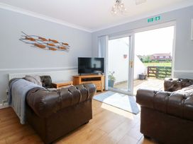 A living room with a sofa and a television at Beach House (Ty Traeth) in Deganwy