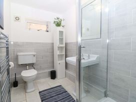 A bathroom featuring a shower, sink, and toilet at Beach House (Ty Traeth) Deganwy