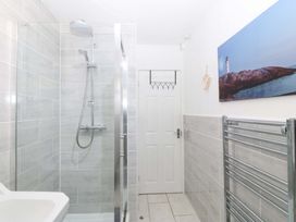 A bathroom with a shower and towel radiator at Beach House (Ty Traeth) Deganwy