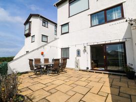 An outdoor seating area with a table and chairs at Beach House (Ty Traeth) Deganwy