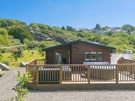A cabin with a deck and hot tub at Costentyn, Tor Down Quarry in St Breward