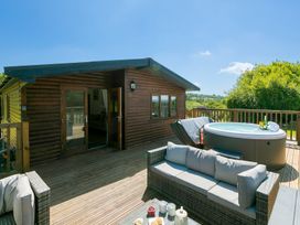 An outdoor area with a hot tub and seating at Costentyn, Tor Down Quarry St Breward