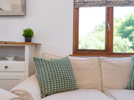 A living room with a sofa and window at Costentyn, Tor Down Quarry St Breward