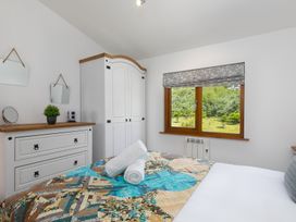 A bedroom with a bed and a wardrobe at Costentyn, Tor Down Quarry in St Breward