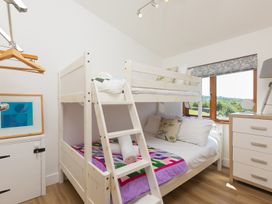 A bedroom with a bunk bed and multiple furniture at Costentyn, Tor Down Quarry St Breward