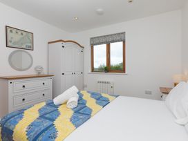 A bedroom with a bed, dresser, and window at Tressa, Tor Down Quarry St Breward
