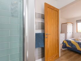 A bathroom area with a towel rail and door opening to a bedroom at Tressa, Tor Down Quarry St Breward