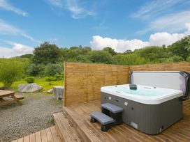 An outdoor area with a hot tub and wooden decking at Tressa, Tor Down Quarry in St Breward