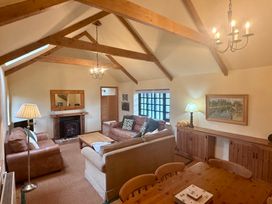 A living room with a sofa, lamp, and fireplace at Meadow Cottage in Golant, near Fowey