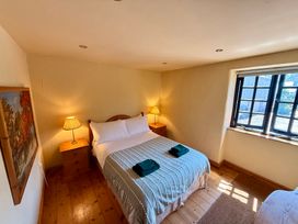 A bedroom with a bed and bedside tables at Meadow Cottage in Golant, near Fowey