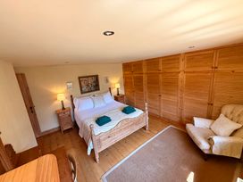 A bedroom with a bed and wardrobe at Meadow Cottage in Golant, near Fowey