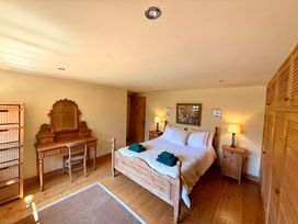 A bedroom with a bed and a dresser at Meadow Cottage in Golant, near Fowey