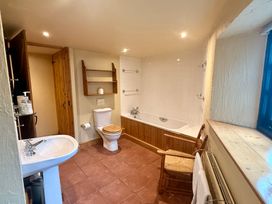 A bathroom with a bath tub and sink at Meadow Cottage in Golant, near Fowey