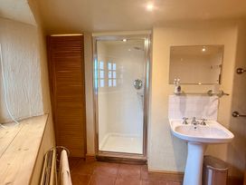 A bathroom with a shower and wash basin at Meadow Cottage in Golant, near Fowey