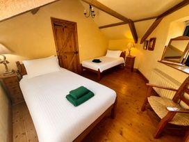 A bedroom with two beds and a dresser at Meadow Cottage, Golant, near Fowey