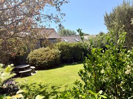 A garden with a seating area and greenery at Meadow Cottage in Golant, near Fowey