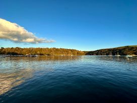 A view of the water with boats and trees in the background at Meadow Cottage in Golant, near Fowey
