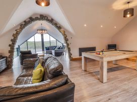 A living room with a pool table and sofas at Granar in Llangwm near Bala
