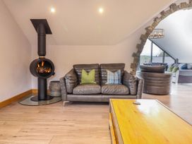 A living room with a sofa and fireplace at Granar in Llangwm near Bala