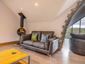 A living room with a sofa and fireplace at Granar in Llangwm near Bala