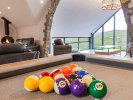 A living room with a billiard table and fireplace at Granar in Llangwm near Bala