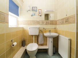 A bathroom with a toilet sink and a radiator at Pier View in Paighton