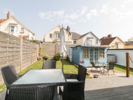 A garden with outdoor furniture and a blue garden shed at Pier View in Paighton