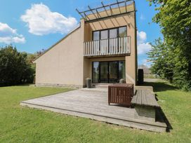 A house with a balcony, deck, and surrounding grass at Frater House, Denton near Harleston