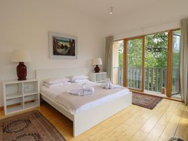 A bedroom with a bed and large windows at Frater House in Denton near Harleston