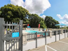 An outdoor pool area with a gate and lounge chairs at Dartmoor View in Gunnislake