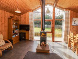 A living room with a wood stove and bookshelf at 26 Dukes Meadow in Greystoke near Penrith