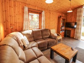 A living room with a sofa and television at 26 Dukes Meadow in Greystoke near Penrith