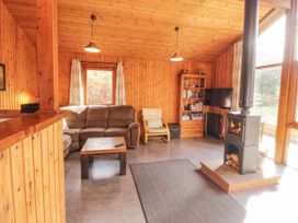 A living room with a sofa and wood stove at 26 Dukes Meadow in Greystoke near Penrith