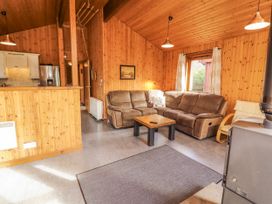 A living room with a sofa, coffee table, and stove at 26 Dukes Meadow, Greystoke near Penrith