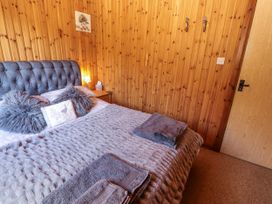 A bedroom with a bed, nightstand, lamp and towels at 26 Dukes Meadow in Greystoke near Penrith