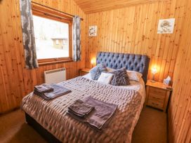 A bedroom with a bed and a window at 26 Dukes Meadow Greystoke near Penrith