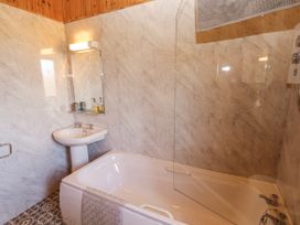 A bathroom with a bathtub and sink at 26 Dukes Meadow Greystoke near Penrith