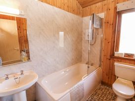 A bathroom with a tub, toilet, and sink at 26 Dukes Meadow in Greystoke near Penrith